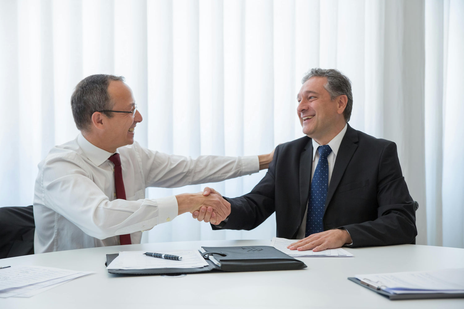 Two business professionals shaking hands after closing a deal, representing effective sales pipeline building software for businesses.